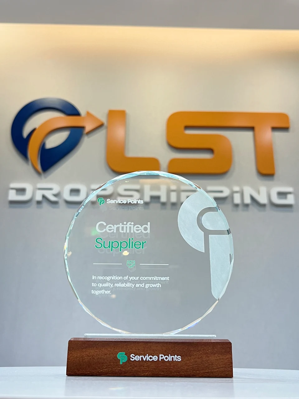 ServicePoints Certified Supplier award presented to LST, photographed in front of the LST office logo